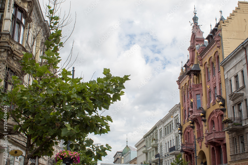  Fragments of beautiful restored ancient buildings of European cities against the blue sky on a summer sunny day.