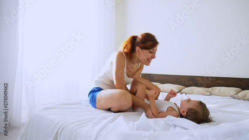 Mom plays with her son in the bedroom