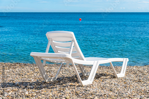 Empty white plastic chaise lounge on the background of the sea