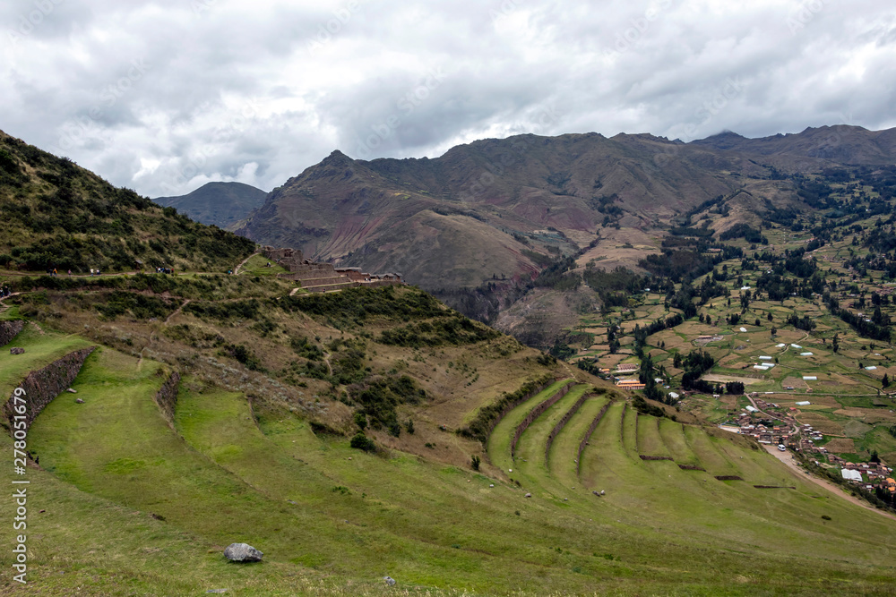 Landscape with green Andean Mountains and Inca ruins on the hiking path in Pisac archeological park, Peru
