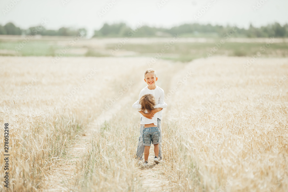 Two adorable kids, little girl and boy, embracing in wheat field. Two adorable kids, little girl and boy, embracing in wheat field.