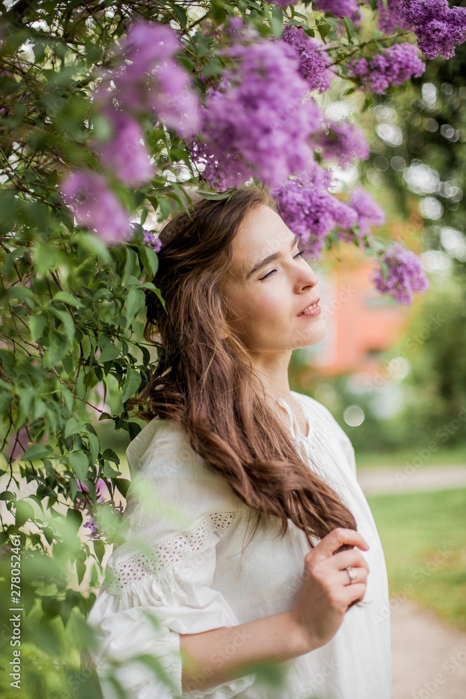 Portrait of a beautiful young woman near the blossoming lilac. Spring. Portrait of a beautiful young woman near the blossoming lilac. Spring.
