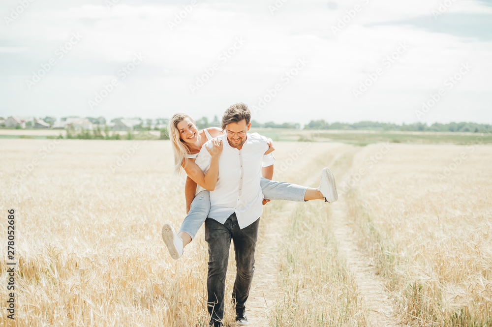 Happy young couple enjoying in the wheat field.