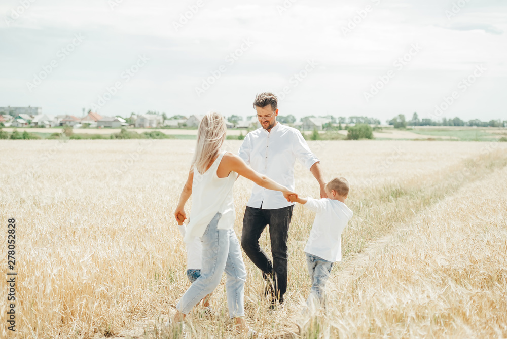 Happy family with children having fun round dancing holding hands together in wheat field. Happy family with children having fun round dancing holding hands together in wheat field.