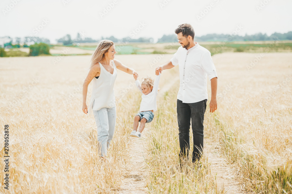 Cute little girl on walk with parent in wheat field on sunny day. Family vacation concept with copy space Cute little girl on walk with parent in wheat field on sunny day. Family vacation concept with copy space