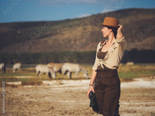 Beautiful woman with binoculars at savanna in Kenya © Nejron Photo