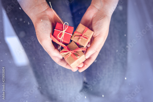 Weihnachten, Verschenken - Junge Frau hält drei Geschenke mit Recyclingpapier vor sich photo