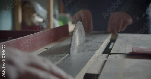 Close-up shot headsaw cutting the wood boards at manufacture . photo