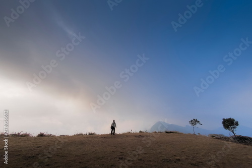 Mountain view of a man standing on top hill with cloudy sky background  Phu Chi Fa  Phu Chee Fah   Chiang Rai  Thailand.