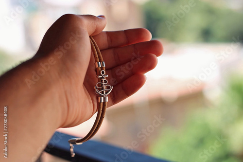 Hand holding a silver bracelet.