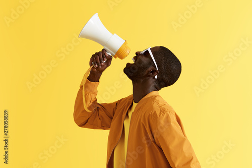 Vászonkép Advertising. Man screaming announcement in megaphone portrait
