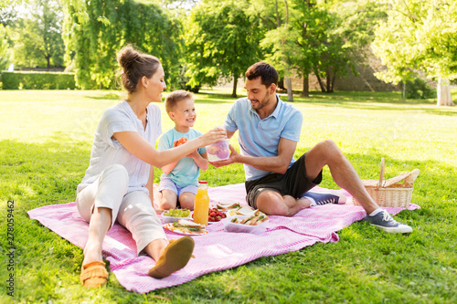 family, leisure and people concept - happy mother, father and little son having picnic at summer park © Syda Productions