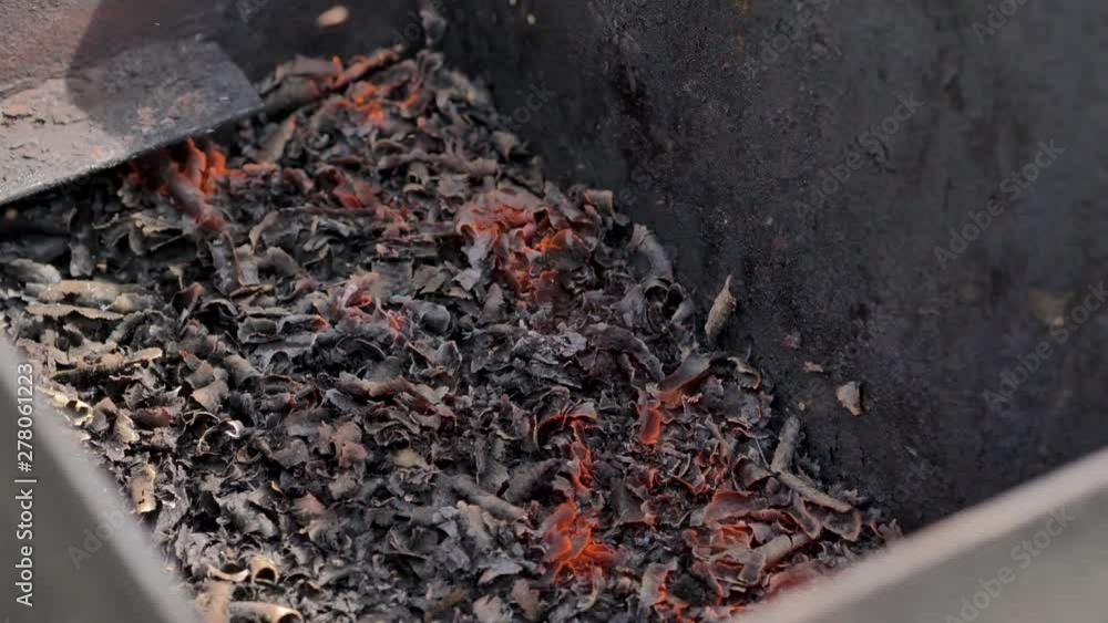 Coal burning in a metal box. Sparks fly, shot close-up. Coal burning in a metal box. Sparks fly, shot close-up.