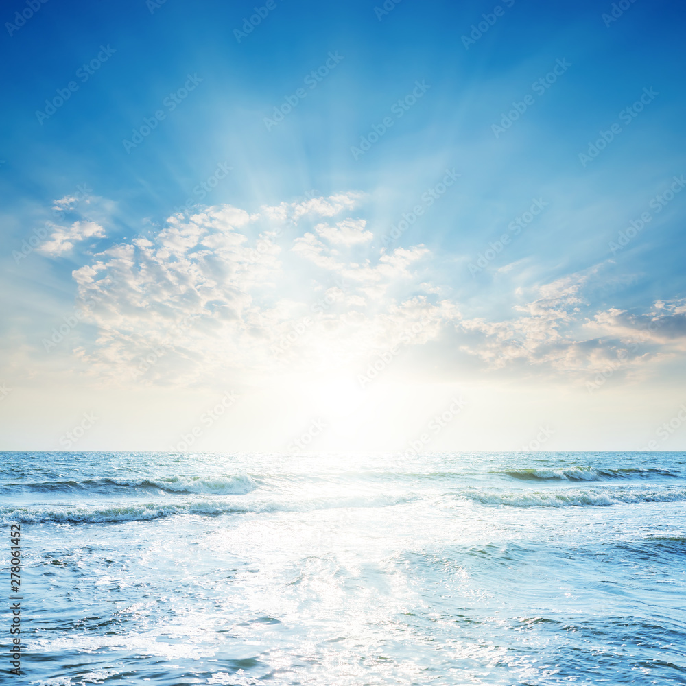 Obraz premium bright sunset in clouds over blue sea