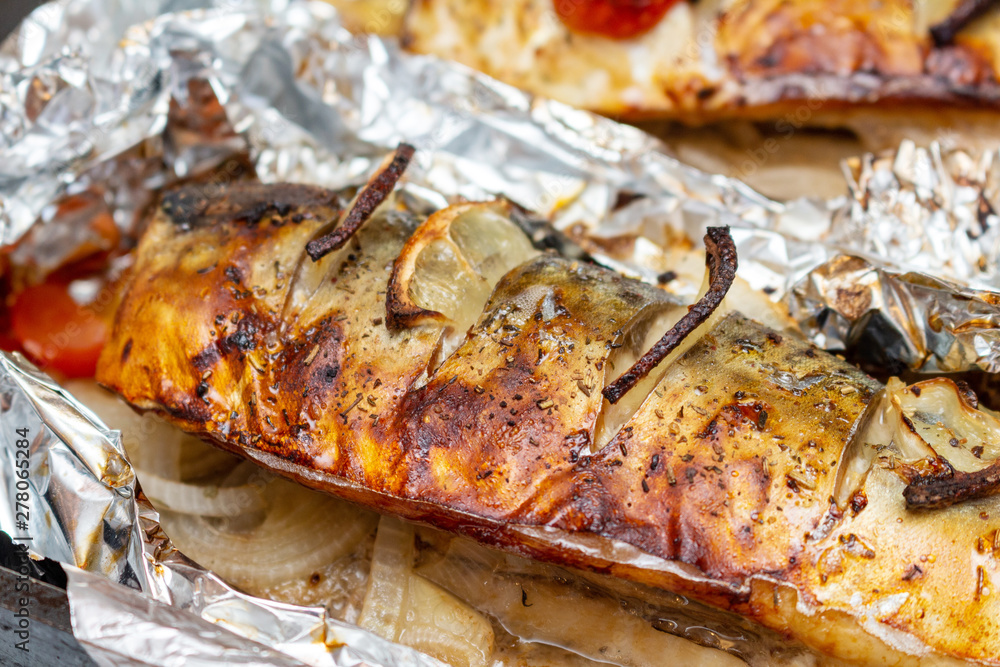 Fried mackerel on the foil with lemon and cherry tomatoes healthy delicious tasty food close up selective focus