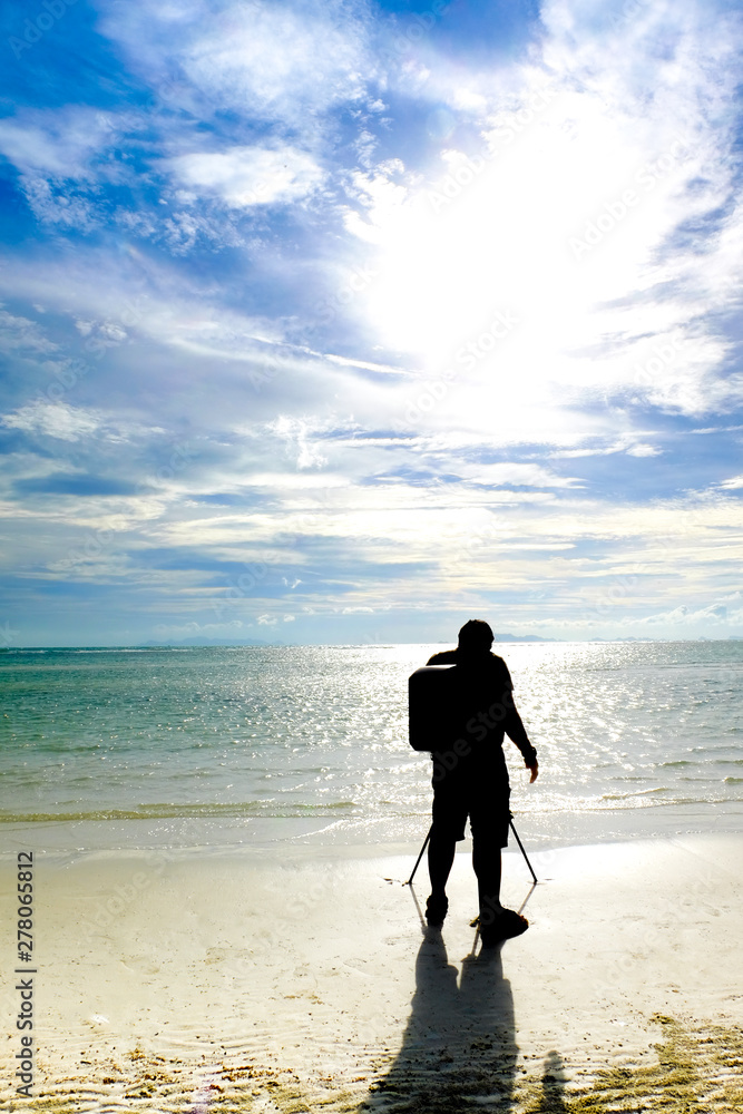 Naklejka premium Silhouette of the photographer. blue sky and white sand. 