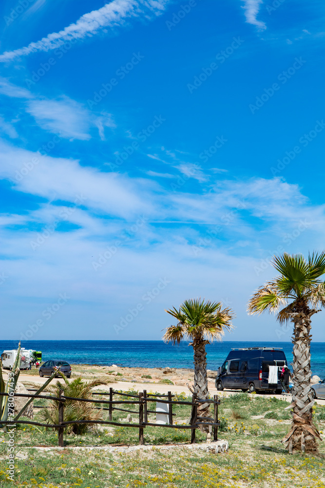 Camper, mobile home or caravan vacation, free parking of beach with palm trees and blue sea