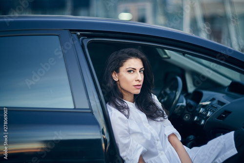 Young business woman sitting in the car on passenger seat