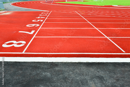Texture of running racetrack red rubber racetracks in outdoor stadium are 8 track and green grass field,empty athletics stadium with track,football field, soccer field. 