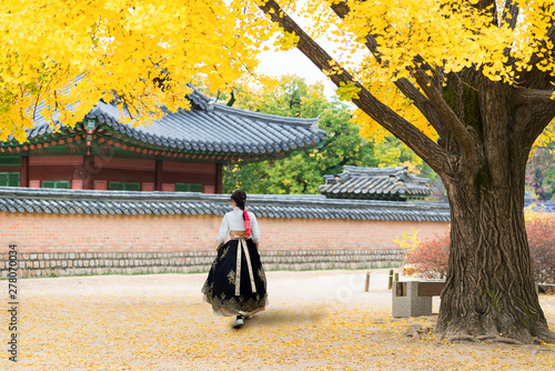Canvas Print Asian Korean woman dressed Hanbok in traditional dress walking in Gyeongbokgung Palace in autumn season at Seoul, South Korea