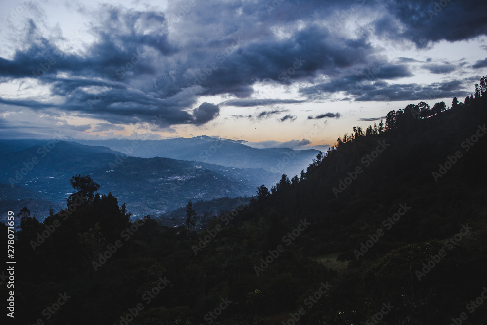 Waning sunlight over the Cundinamarca Valley near Bogotá, capital city of Colombia. Pine trees and evergreens grows over the mountainside Waning sunlight over the Cundinamarca Valley near Bogotá, capital city of Colombia. Pine trees and evergreens grows over the mountainside