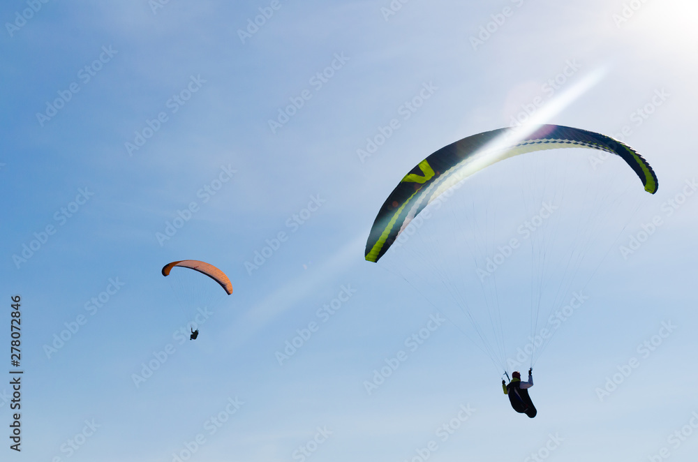 Paragliding in the sky. Two paraglider fly over the mountain valley. Competitions with paragliding, Russia, Siberia Paragliding in the sky. Two paraglider fly over the mountain valley. Competitions with paragliding, Russia, Siberia