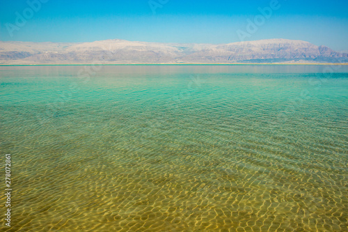 dead sea shallow water shoreline peaceful idyllic Israeli nature scenery landscape in healthy resort region with mountain background, travel and vacation wallpaper pattern picture, copy space 