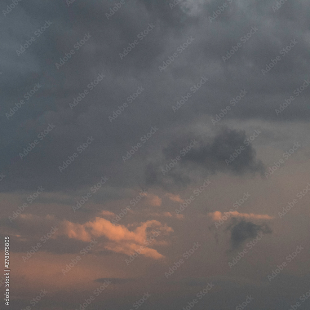 Obraz premium Orange lights and dark thunderstorm clouds in the sky.