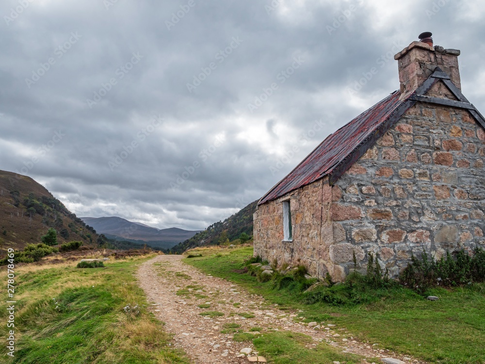 A mountain bothy in the highlands of Scotland on a cloudy, stormy day
