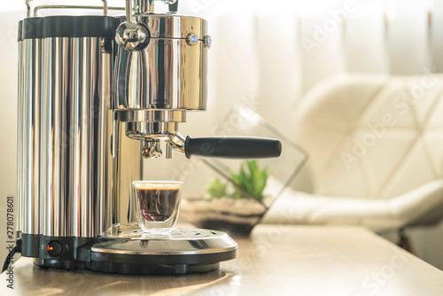 Coffee machine on table in sunlit room  home  office coffee brewing  appliances.