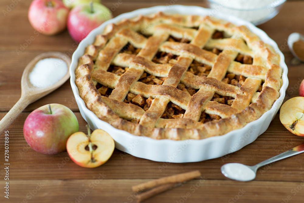food, culinary and baking concept - close up of apple pie with cinnamon and sugar on wooden table food, culinary and baking concept - close up of apple pie with cinnamon and sugar on wooden table