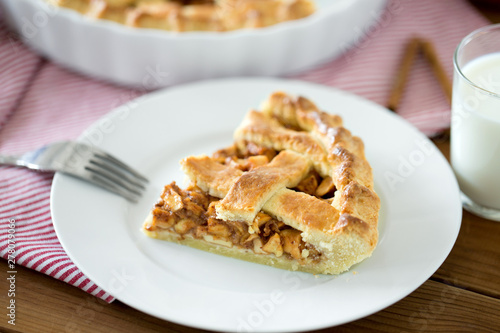 food, culinary and baking concept - close up of apple pie and fork on plate