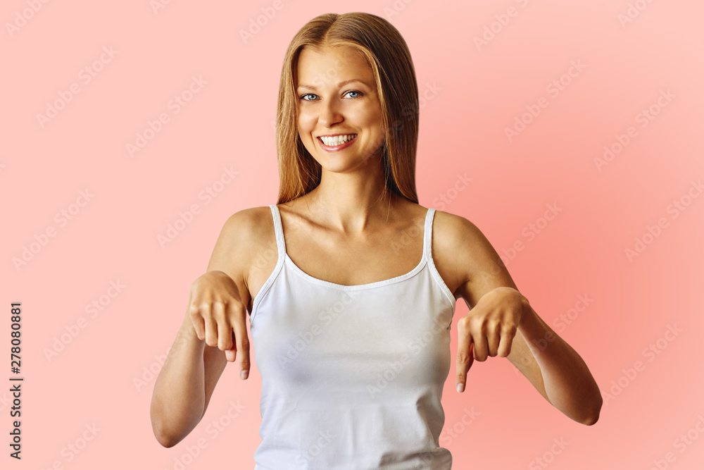 Happy smiling woman pointing down with index fingers Happy smiling woman pointing down with index fingers