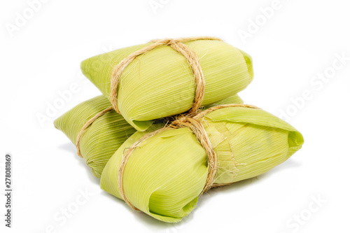 Brazilian pamonha on white background, typical dessert of the rural cities of Brazil. Sweet corn with cheese served in the straw. Rural sweets made in the states of Minas Gerais and Goiais. photo