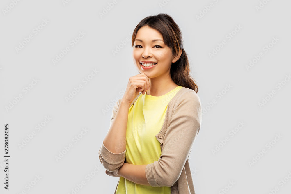 people, ethnicity and portrait concept - happy asian young woman over grey background people, ethnicity and portrait concept - happy asian young woman over grey background