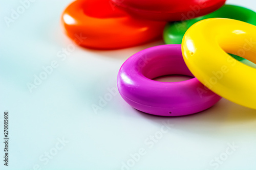 Colorful plastic rings on a white background to be stacked in a tower. © rarrarorro
