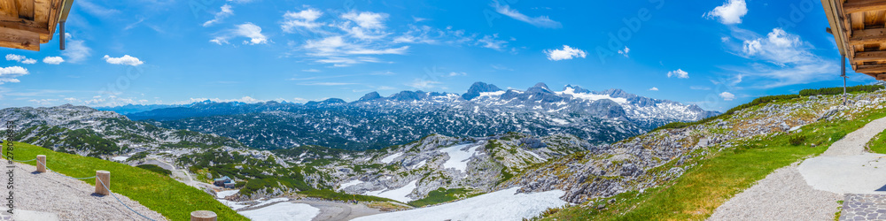 Panoramic view of the European Alps from Dachstein Krippenstein, Austria. Blue sky, rocky hills and snowy mountains on the horizon. Travel, wanderlust concept. Panoramic view of the European Alps from Dachstein Krippenstein, Austria. Blue sky, rocky hills and snowy mountains on the horizon. Travel, wanderlust concept.