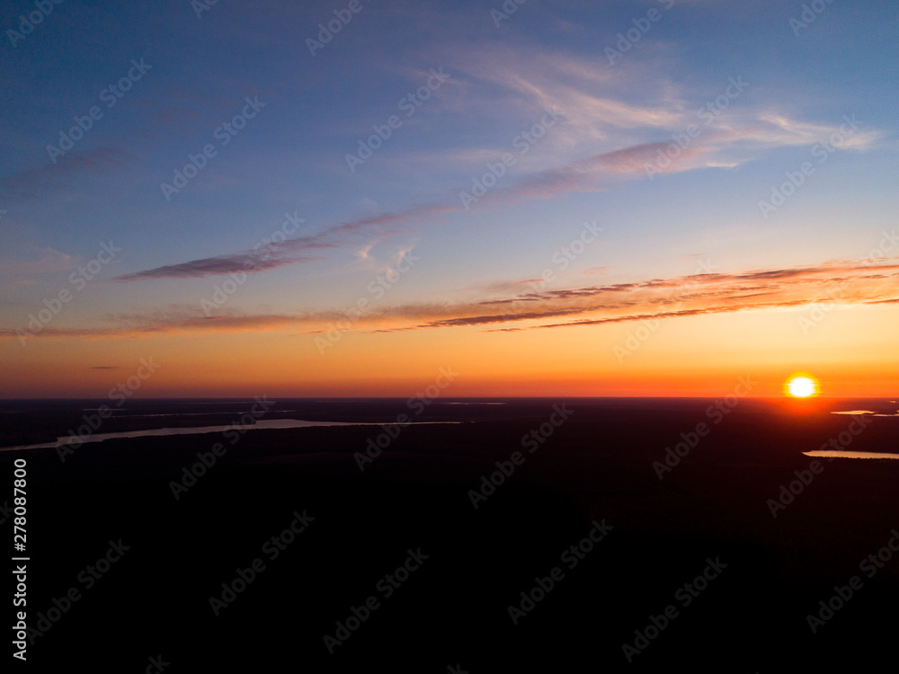 Aerial view sunset sky background. Dramatic gold sunset sky with evening sky clouds over the lakes. Stunning sky clouds in the sunrise. Above the Sky landscape. Panoramic sky view.