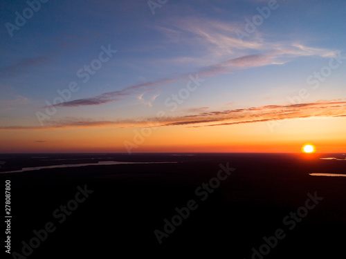 Aerial view sunset sky background. Dramatic gold sunset sky with evening sky clouds over the lakes. Stunning sky clouds in the sunrise. Above the Sky landscape. Panoramic sky view.