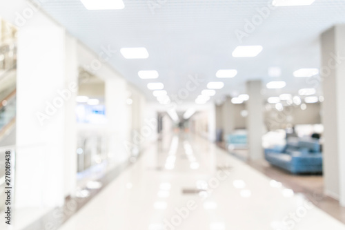 Blurred defocused bokeh background of exhibition hall or convention center hallway. Business trade show modern white interior architecture. Abstract blur modern business office background