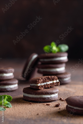 Chocolate homamade sandwich cookies on dark background. Selective focus photo