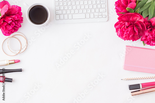 Flat lay blogger or freelancer workspace with a notebook  keyboard  red peonies on a white background