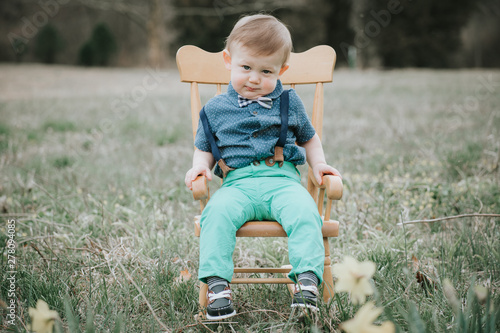boy sitting on chair on green grass field photo