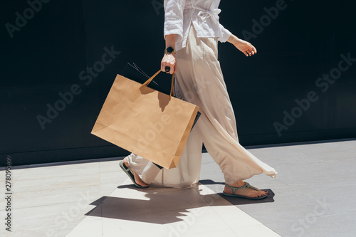 Unrecognisable stylish woman walking with shopping bags. photo