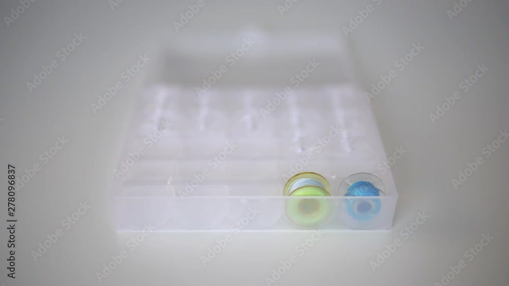 girl lays spools of thread in a special tray girl lays spools of thread in a special tray