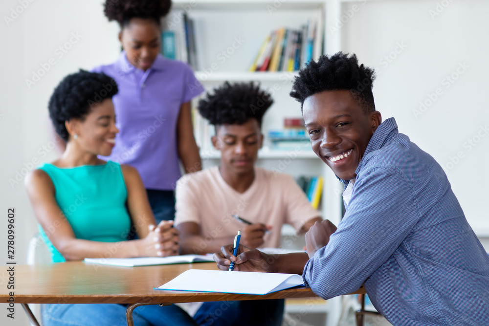 African american male student learning at desk at school African american male student learning at desk at school