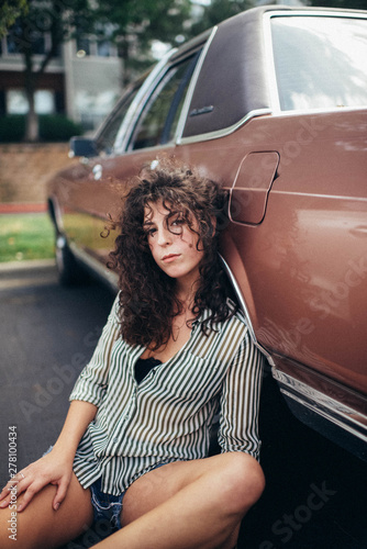 woman leaning on brown sedan photo
