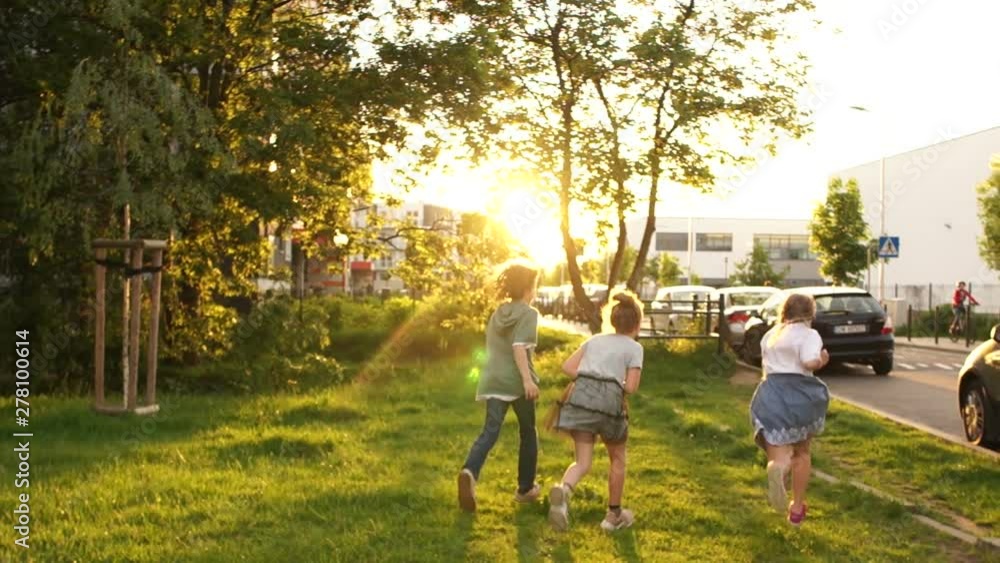 Children run into the distance in the city park after school. School friendship, back to school Children run into the distance in the city park after school. School friendship, back to school