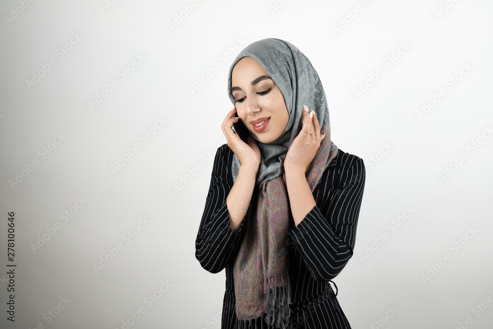 young beautiful Muslim woman wearing turban hijab headscarf talking on the smartphone isolated white background young beautiful Muslim woman wearing turban hijab headscarf talking on the smartphone isolated white background