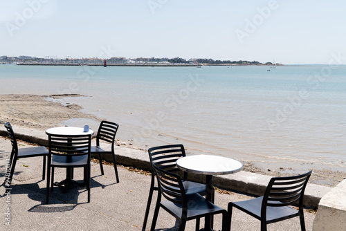 Table and chairs on coast of La Rochelle old port bay in France